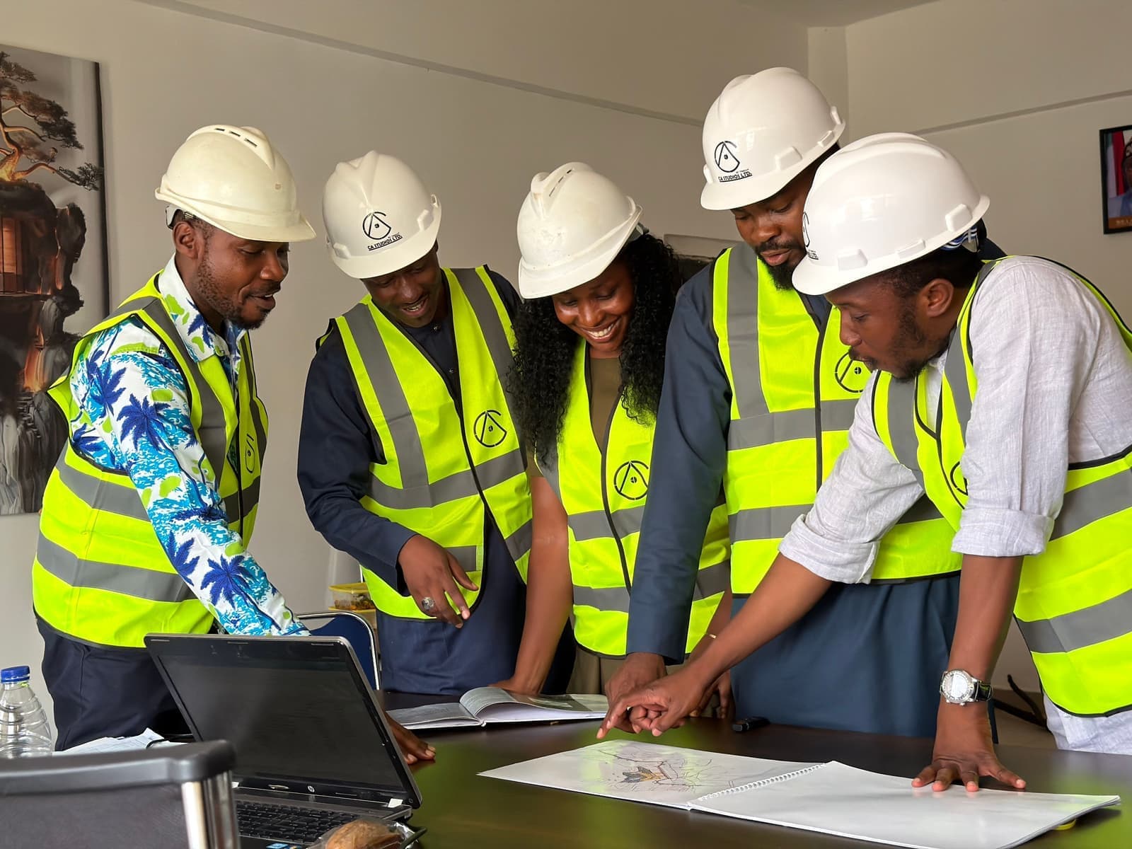 Shengli team in safety helmets and vests reviewing site drawings together